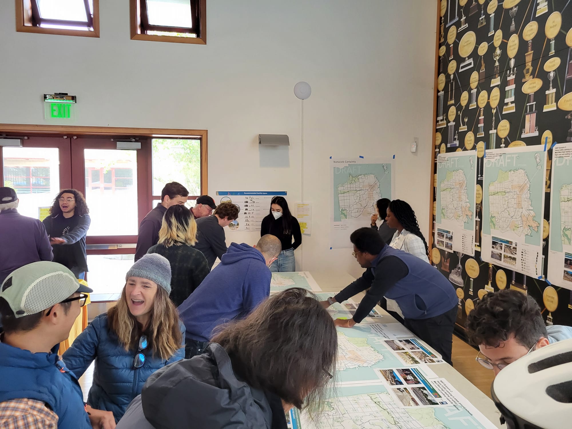 People gather around a table with maps.