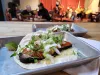 A brisket taco on a silver tray.